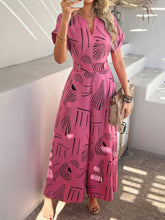 Model in hot pink Serenoor jumpsuit with tan open-toe heels, posing at a vibrant beachside summer soirée.