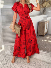Front view of Serenoor jumpsuit in scarlet showcasing V-slit neckline, paired with jewelry, tan clutch, and heels at a beach house.