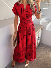 Model in scarlet Serenoor jumpsuit with tan accessories, posing confidently at a seaside sunset cocktail party.