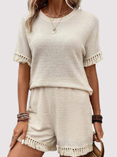 Model wearing the cream Shakaluxe Tassel Shorts Set styled with jewelry, a brown handbag, and sandals ready for a boardwalk beach adventure. 