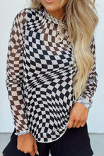Side view of black ChicGrid checkered long sleeve blouse with mock neckline, showcasing slight stretch fabric and tailored feminine fit on model , paired with black shorts.