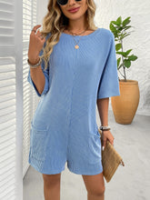 Close-up side shot of sky blue romper and front pocket.