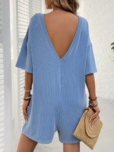 Back view of sky blue romper featuring deep V-back.
