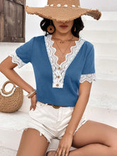 Lifestyle image of model in a sky blue Lace Detail V-Neck Short Sleeve T-Shirt, walking through a sunny park with a crossbody bag and casual sneakers.