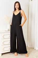 Solvara Balance Jumpsuit’s side view highlights the flawless wide-leg drape in a classic black hue highlighting functional pockets.