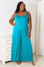 Sky Blue Solvara Balance Jumpsuit styled with statement earrings and clear heels for a sunset dinner by the beach house.