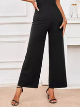 Close-up of Black Soralia DrapeSuit’s moisture-wicking, soft polyester-spandex fabric with delicate stitching details with black heels for versatile appeal.