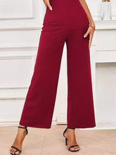 Close-up of Burgundy Soralia DrapeSuit’s luxurious, soft-touch polyester-spandex fabric and color-retentive texture with black heels.
