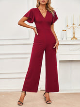 Model in Burgundy Soralia DrapeSuit, styled for weddings or romantic dinners, showcasing rich color and flutter sleeve design.