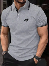 Model in gray Stallion Crest Luxe Polo featuring black collar, button placket, and stallion chest emblem