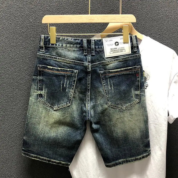 Back view of StoneRidge Distressed Vintage Skinny Jean Shorts in dark blue on hanger.
