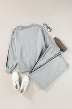 flat lay of striva twinset light gray back with white sneakers water bottle reading glasses