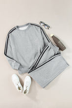 flat lay of striva twinset light gray front with white sneakers water bottle reading glasses