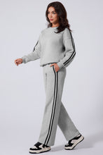 striva twinset light gray side view walking styled with black shoulder purse black white sneakers
