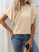 Model in a tan Round Neck Flutter Sleeve T-Shirt, styled with wide-leg linen pants and a straw tote at a sunny garden brunch.