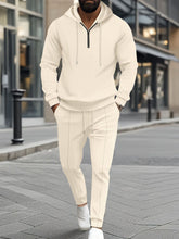 A man shopping in Los Vegas wearing the beige Tavvion TerrainFlex Waffle-Knit Half Zip Hoodie and Pants Set  paired with white loafers.