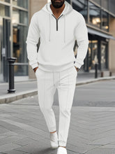 Model shopping in Portland wearing the white Tavvion TerrainFlex Waffle-Knit Half Zipper Hoodie and Pants Set  paired with white sneakers.