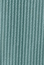 Close-up view of teal Nolavelle mini dress fabric showcasing ribbed texture and fine stitching quality.