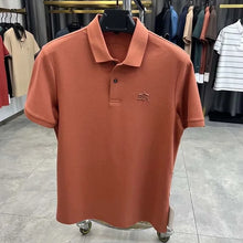 TexturaLoom Men’s Embossed Letter Polo Orange Front View on Hanger.