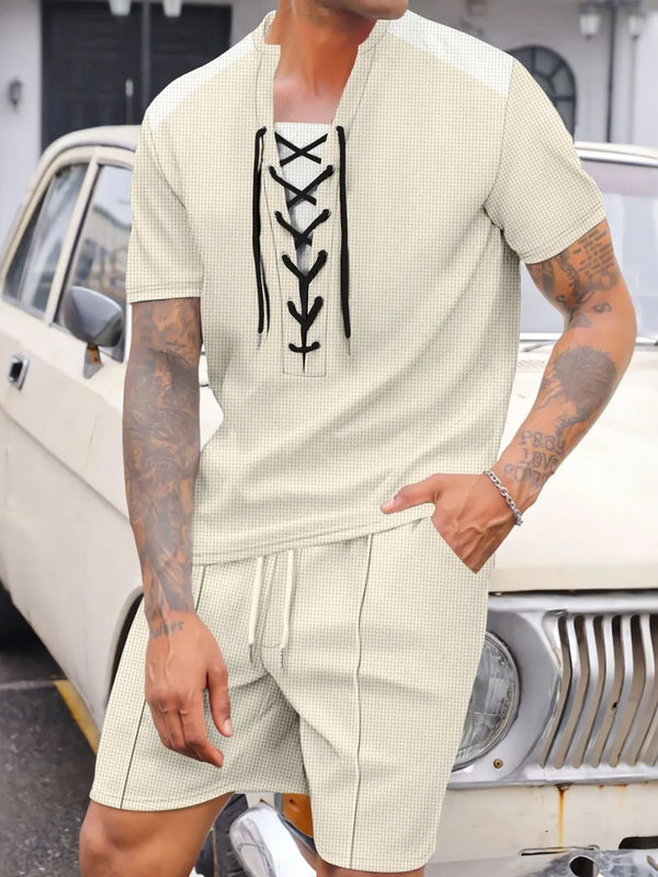 Men's beige Valtren WaffleEdge lace-up waffle knit top and shorts set, front view of model sitting on an antique Bentley in a mansion driveway.