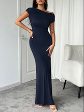 Model wearing dark blue Vareliya Ruched One-Shoulder Maxi Dress with silver hoop earrings and matching clutch.