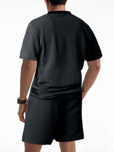 Back view of men’s black Vayrix TextureFlex top and shorts set showcasing pique textured fabric and relaxed fit