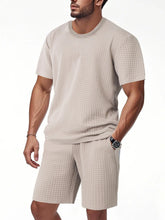 Men's khaki textured top and shorts set, close-up with hand in pocket