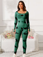 Woman model in dark green PrismFlow jumpsuit, front view highlighting scoop neck and tie-dye print.