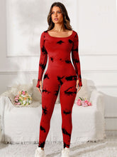 Model in deep red Prism Flow jumpsuit, front view highlighting scoop neck and tie-dye print.