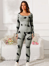 Model in gray Prism Flow jumpsuit, front view highlighting scoop neck and tie-dye print.