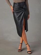 Close up of twisted knot detail on Velvanyx Twist Skirt in black with crossed legs