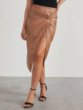 Close up of twisted knot detail on Velvanyx Twist Skirt in tan with crossed legs