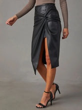 Side walking pose wearing Velvanyx Twist Skirt black with side slit