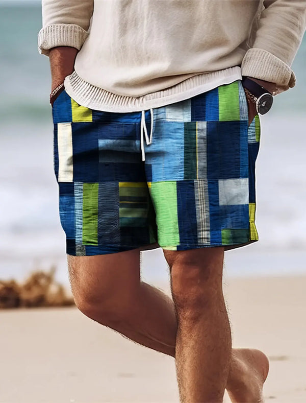 Person walking on beach wearing blue geometric color block shorts.