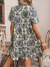 Back view of Vesaluna Paisley Print Tie Neck Dress in beige, showcasing short sleeves and flattering A-line silhouette.
