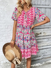 Model wearing Vesaluna Paisley Print Tie Neck Dress in pink, styled with a straw hat and nude heels for a chic daytime look.