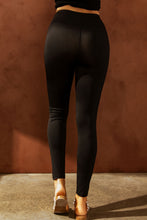 Woman back angle of veyraze rebeledge dissed leggings in black styled with sandals. 