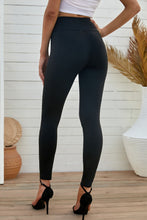 Model back view in black distressed slim-fit leggings, displaying smooth waistband and snug silhouette.