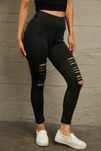Model right side angle in black distressed leggings, emphasizing side distressing and form-flattering cut.