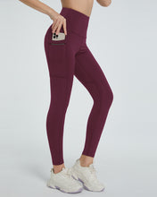 side view showing stretch fabric of virexaform sculpt leggings burgundy with phone in side pocket