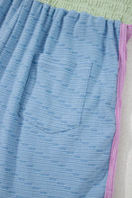 Close-up of side pocket and contrast trim on Vivenza Luxe™ Knit Shorts in light blue.