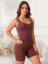 Model stretching pre-workout in dark brown Vyvenca SculptFit Active Romper paired with trainers.