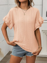 Close-up of contrast round neckline and soft fabric texture of the blouse in watermelon pink, highlighting stitching and relaxed sleeve design.