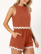 Model  side view wearing an orange-red wavy mirage contrast trim short set paired with Jewelry, highlighting pocket detail - white background.