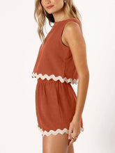 Model side view wearing a Orange-Red wavy mirage contrast trim short set detailing wavy trim.