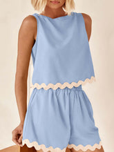 Model wearing a pastel blue wavy mirage contrast trim short set with a white background.
