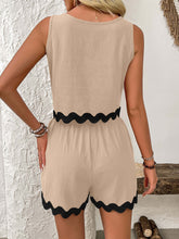 a woman showcasing the back of a tan Wavy Mirage Contrast Trim Shorts Set near a white marble wall.