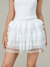 White LacéraBloom Women’s Ruffle Lace Bow Shorts with layered ruffles and decorative bow, model front view.