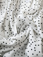 Close-up of white EverDot Flutter Top's premium fabric texture and button detailing.