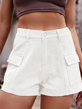 Woman in a striped t-shirt and white Joyful Journey Denim shorts enjoying an outdoor picnic.